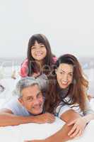 Parents with their daughter lying on bed