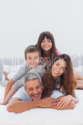 Parents with their children lying on bed