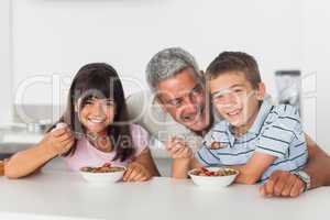 Happy father talking with his children during their breakfast