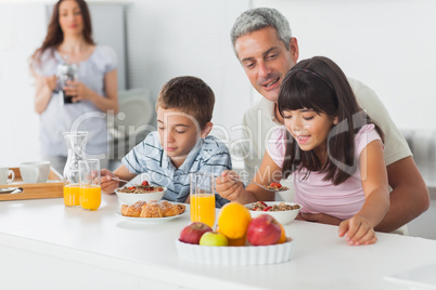 Cute family eating breakfast in kitchen together