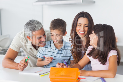 Smiling family drawing together in kitchen