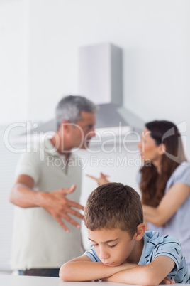 Couple having dispute in front of their sad son