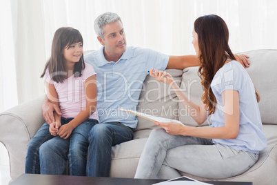 Parents with their daughter sitting on sofa