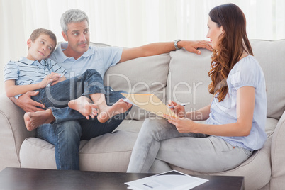 Parents with their son sitting on sofa