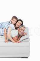 Little boy lying on his parents on sofa