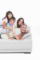 Children lying on their parents on sofa