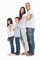 Portrait of a cute family in single file doing thumbs up at came