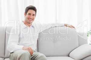 Stylish young man sitting on sofa