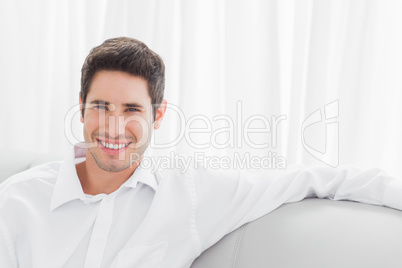 Handsome young man sitting on sofa