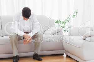 Troubled young man sitting on sofa