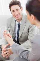 Happy coworkers talking sitting on sofa