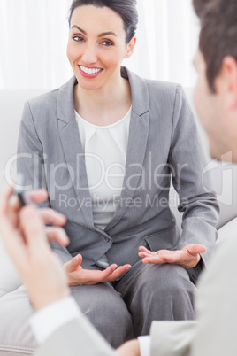 Cheerful coworkers talking sitting on sofa