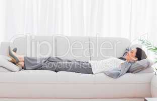 Businesswoman lying on sofa relaxing