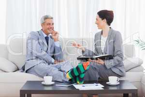 Funny businessman wearing stripey socks and laughing with his co