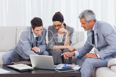 Business people using laptop and working together on sofa