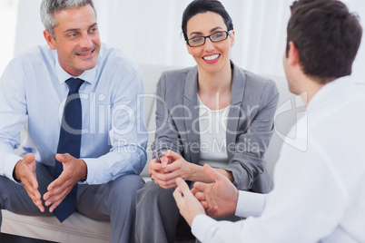 Coworkers talking and working together on sofa