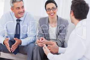 Coworkers talking and working together on sofa