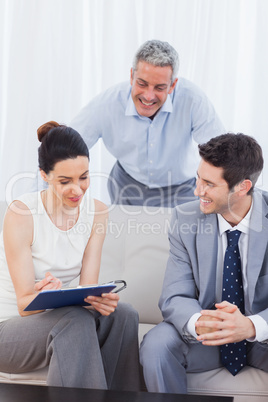 Woman signing a contract as husband and salesman are watching