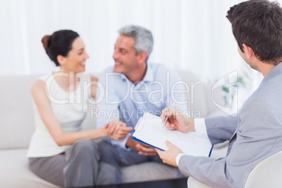 Couple speaking while salesman is holding contract