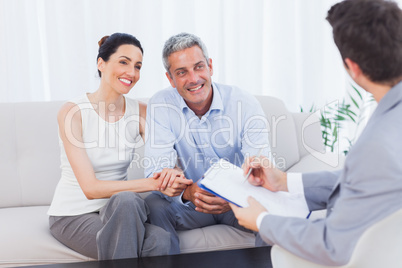 Couple listening to salesman holding contract