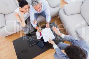 Salesman showing contract to couple who are about to sign