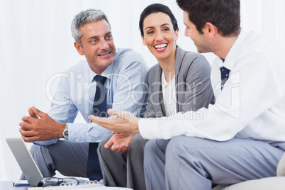 Happy business people working with their laptop on sofa