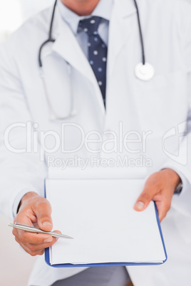 Doctor holding and presenting his clipboard and pen