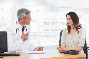 Serious patient talking with her doctor about illness