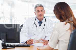 Doctor listening to his patient talking about her illness
