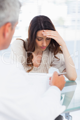 Sad woman listening to her docter talking about a illness