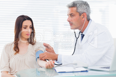Doctor taking blood pressure of his patient