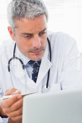 Concentrated doctor watching something on his laptop