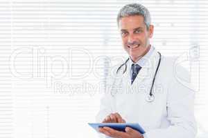 Smiling doctor using tablet pc