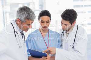 Nurse and doctors looking together a file