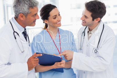 Smiling nurse and doctors looking together a file