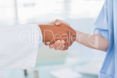 Hands of a doctor and nurse shaking hands