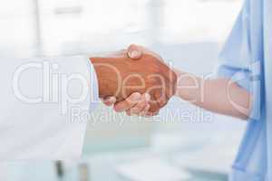 Hands of a doctor and nurse shaking hands