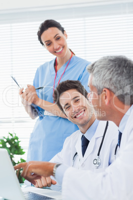 Happy nurse listening to doctors talking about something on thei
