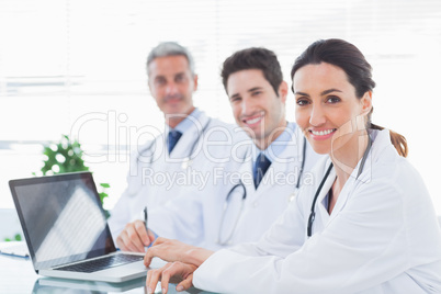 Doctors with laptop smiling at camera