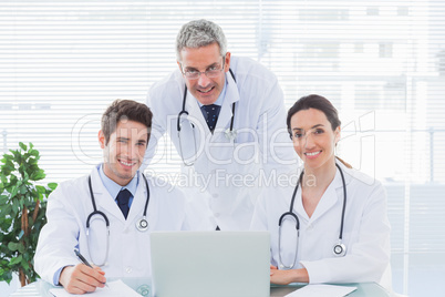 Team of doctors working together with their laptop looking at ca