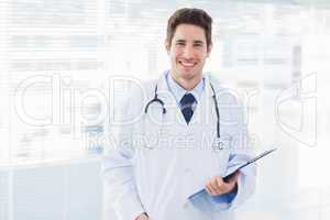 Smiling doctor holding files and looking at camera