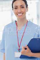 Smiling nurse holding files and looking at camera