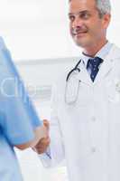 Happy doctor does handshake with a nurse