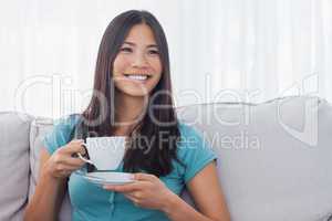 Young asian woman drinking cup of tea
