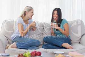 Friends laughing and drinking coffee together