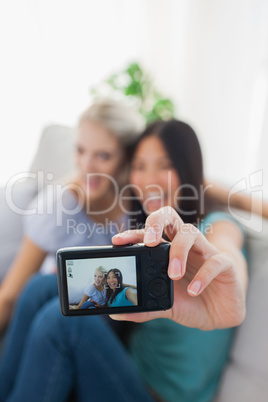 Two happy friends taking photo with camera