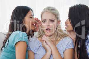 Friends telling secret to blonde woman