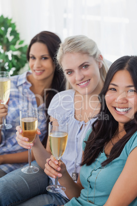 Happy friends enjoying white wine together looking at camera