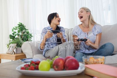 Laughing friends playing video games and having fun