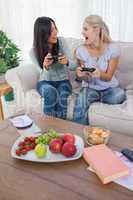 Cheerful friends playing video games and laughing